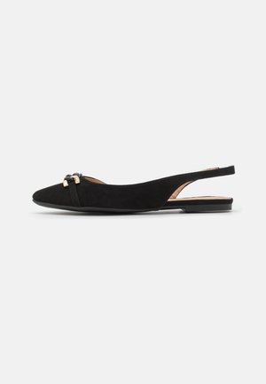 Chaussure plate slingback en daim noir à bout pointu avec détail boucle dorée sur petit talon sur fond clair uni.