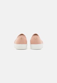 Rosa lerret slip-on sko med en hvit gummisåle, med en liten gullakcent på hælen og et enkelt design uten synlige mønstre.