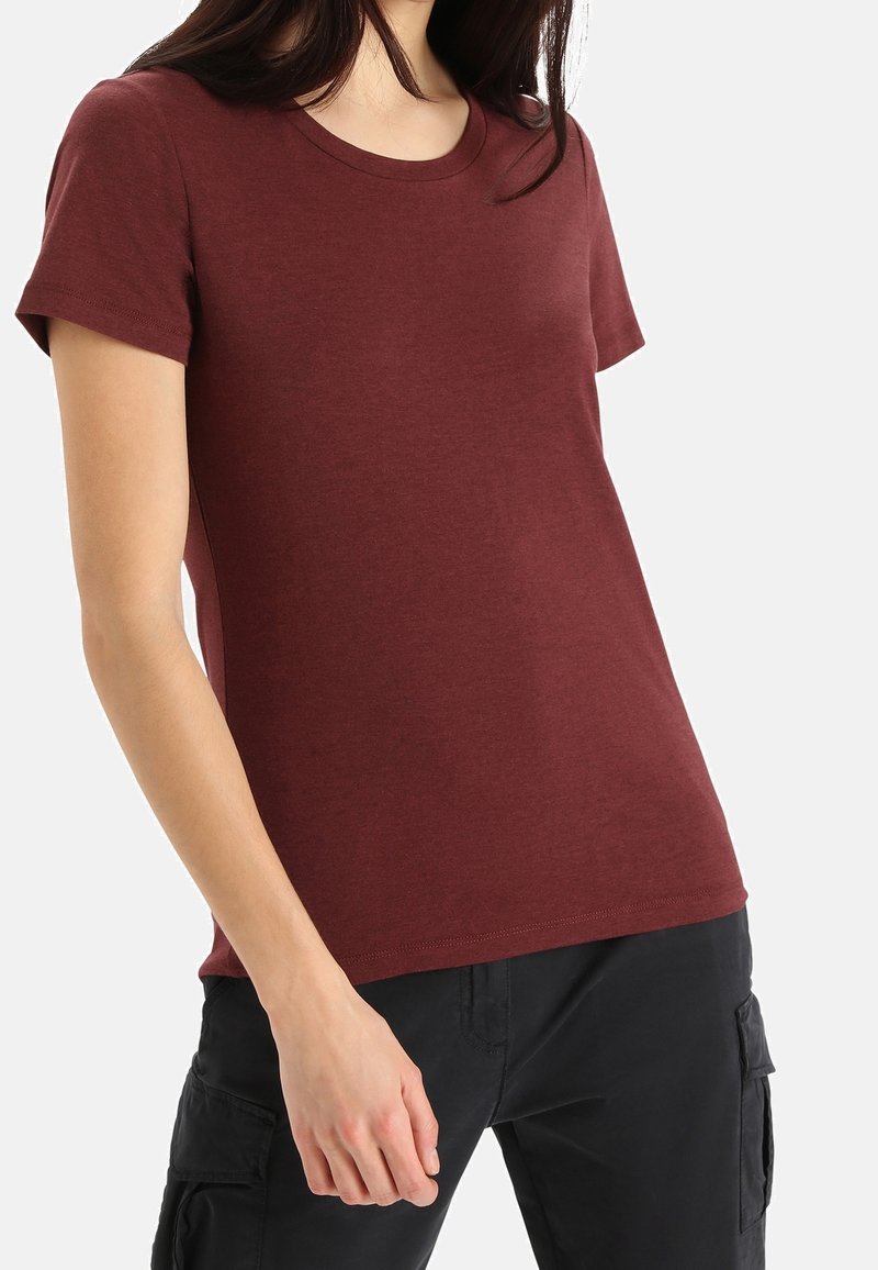 Bordó tričko s krátkým rukávem a kulatým výstřihem. Měkká látka, klasický střih a jednoduchý design, doplněné o černé cargo kalhoty.