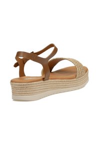 Sandalia de cuero marrón con plataforma de yute tejido, correa trasera ajustable y plantilla acolchada. Cuenta con una suela con capas y textura.