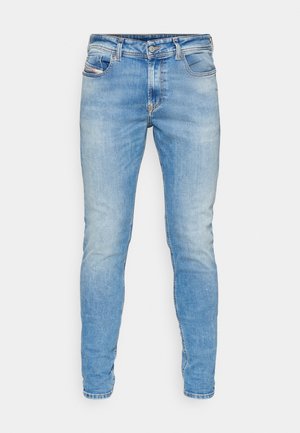 Jean skinny en denim bleu avec taille mi-haute, cinq poches et un léger effet usé à l'avant. Couture classique et coupe ajustée.