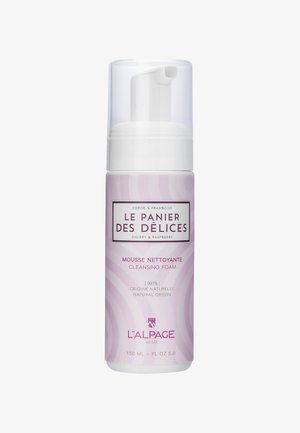 Schiuma detergente in una bottiglia cilindrica rosa e bianca con pompa. L'etichetta presenta onde decorative e testo in colori a contrasto. 150 mL.