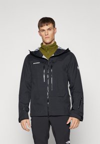 Chubasquero negro impermeable con capucha gris, cierre frontal con cremallera, dos bolsillos frontales con cremallera y puños ajustables, combinado con una capa interna verde.