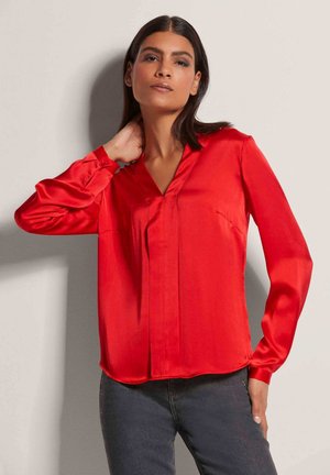 Rode satijnen blouse met een V-hals, lange mouwen en kleine plooien aan de voorkant. Glad textuur, getailleerde pasvorm en een gebogen zoom.