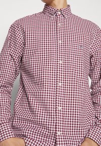 Rood-wit geruite button-up shirt met een kraag, lange mouwen en een borstzak. Zacht materiaal met een gestructureerde pasvorm.
