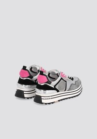 Paire de baskets grises, noires et roses avec des semelles épaisses à rayures et des accents métalliques argentés au talon, positionnées avec les talons face à l'avant.