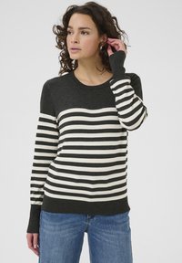 Pull rayé en gris foncé et crème, avec un col rond, des manches longues et une coupe décontractée, arborant un motif rayé contrasté.