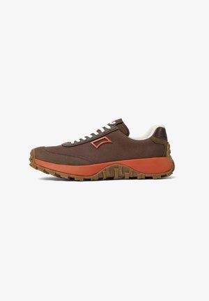 Brown fabric sneakers with white laces, orange accents, and textured brown rubber outsole. Features a distinctive side emblem.