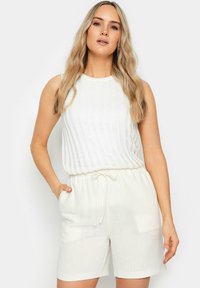 Witte, geribbelde mouwloze top gecombineerd met witte shorts met trekkoord. Lichtgewicht stof met zakken. Casual ontwerp en ontspannen pasvorm.