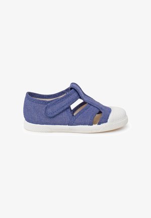 Sandalia azul para niños con correa ajustable de Velcro, puntera blanca de goma y diseño lateral abierto sobre fondo blanco.