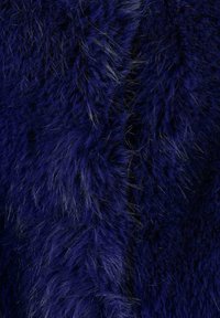 Tessuto in pelliccia sintetica di colore blu scuro con una texture morbida e densa, e sottili fili più chiari sparsi in tutto.