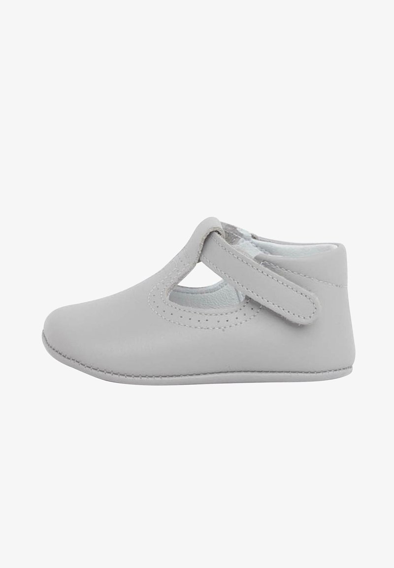Chaussure en cuir gris avec un bout arrondi, un design découpé sur le côté et une bride Velcro pour la fermeture. Texture douce et lisse avec des détails de couture.