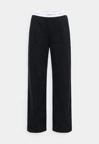 Melnas sporta bikses, kas izgatavotas no mīkstas auduma, ar platām kājām un baltu elastīgu jostasvīru ar "Calvin Klein" logotipu.