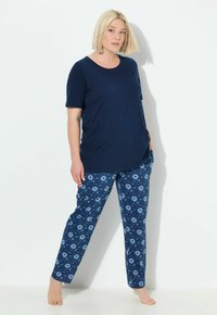 Navyblauw T-shirt met korte mouwen, gecombineerd met gestreepte blauwe pyjamabroek met cirkelvormige motieven. Zachte stof met een ontspannen pasvorm.