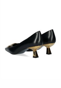 Décolleté nere in pelle con punta a mandorla, caratterizzate da dettagli in metallo dorato e un design unico del tacco geometrico. Texture liscia con dettagli minimi.