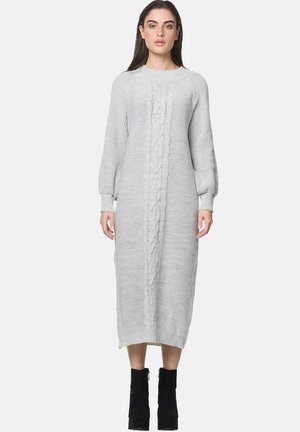 Vestito a maglia grigio con maniche lunghe a sbuffo, caratterizzato da un motivo centrale a treccia e orlo a coste, indossato con stivali neri alla caviglia.