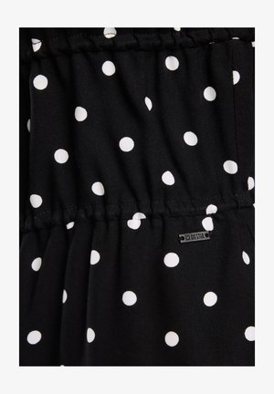 Schwarzer Stoff mit weißen Pünktchen, mit geraffter Textur und einem kleinen Metall-Logo-Tag mit der Aufschrift "BIG STAR" in der Nähe des Saums.