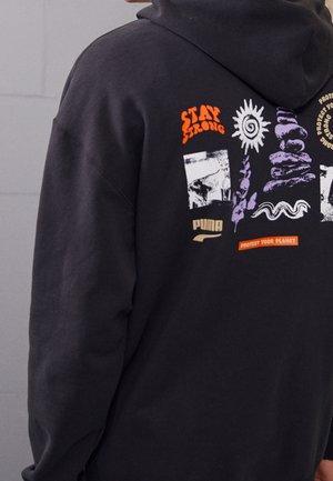 Czarna bluza z kapturem z kolorowymi grafikami o tematyce ekologicznej i motywacyjnej, zawierająca napisy "Stay Strong", słońce, ułożone kamienie, rośliny oraz tekst "Protect Your Planet".
