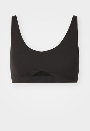 Black bralette featuring a scoop neckline, thick straps, smooth fabric, and a cut-out detail at the center bottom with a subtle elastic band.