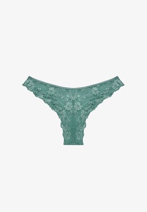 String en dentelle turquoise avec motifs floraux, présentant des bords festonnés et une texture transparente. Les points forts du design incluent une forme taille basse.