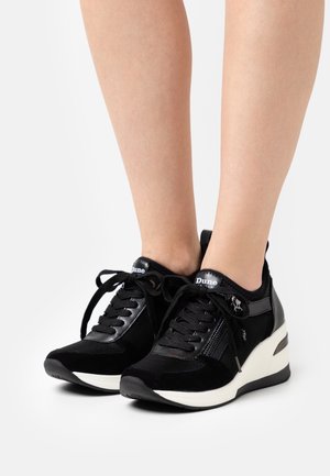 Černé tenisky z semiše a síťoviny, s klínovou podrážkou, šněrováním, zipem a logem na jazyku.