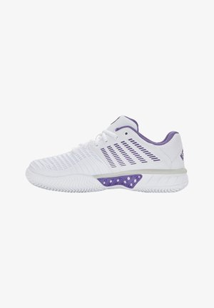 Chaussure de sport blanche avec des accents violets, dotée d'une tige texturée, de panneaux en mesh et d'une semelle en caoutchouc avec un motif de traction en zigzag.