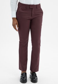 Bordeauxkleurige broek met een tailored fit, gemaakt van gladde stof. Heeft zijzakken, riemlussen en een strakke afwerking. Draagt met zwarte schoenen.