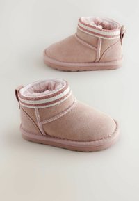 Roze antilop cipele do gležnjeva s mekanim unutarnjim podstavom, koje imaju ukrasnu traku na vrhu i dizajn za jednostavno obuvanje. Ravni gumeni potplat.