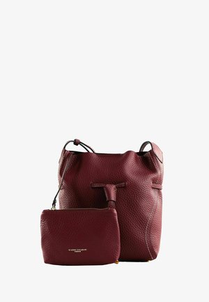 Sac seau en cuir texturé rouge foncé avec une pochette zippée assortie, tous deux arborant un logo doré, sur fond blanc.