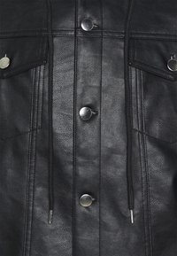 Giacca in pelle nera con bottoni a pressione, finitura testurizzata, due tasche sul petto e dettagli con coulisse lungo la parte anteriore.