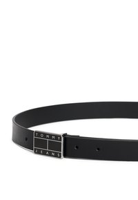 Μαύρη δερμάτινη ζώνη με ασημένια ορθογώνια αγκράφα που φέρει την επιγραφή "TOMMY JEANS." Λείο υφή και πολλαπλές οπές για ρύθμιση.