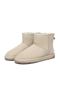 Beige ankle boots made of soft suede, featuring a cozy fur lining, stitched accents, and durable rubber soles for traction.