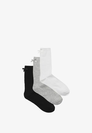 Drei Paar Socken: ein schwarzes Paar mit einer schwarzen Schleife, ein weißes Paar mit einer weißen Schleife und ein graues Paar mit einer grauen Schleife; alle sind knöchellang.