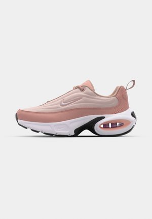 Chaussures Nike avec une tige rose et beige, surface texturée, semelle intermédiaire blanche et semelle extérieure noire. Présente un amorti à air visible au niveau du talon.