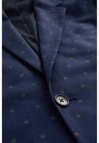 Navy blazer with a textured pattern featuring small, multicolored accents. Includes a single black button and a smooth inner lining.