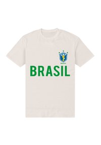 Bílý bavlněný tričko s modro-zeleným logem brazilského fotbalu na levé části hrudi a výrazným zeleným textem "BRASIL" přes přední stranu.