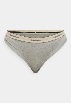 Slip bikini in cotone grigio con fascia elastica beige recante il logo "Calvin Klein". Texture liscia, design a vita bassa e copertura minima.