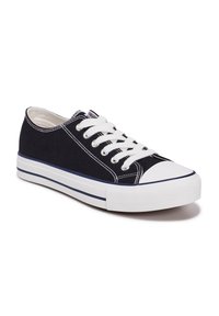 Zapatilla de lona en color azul marino con cordones blancos, puntera de goma y suela blanca contrastante que presenta un acento a rayas en la parte inferior.