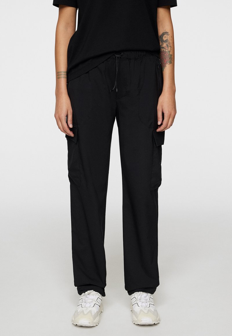 Pantaloni cargo neri con una vestibilità rilassata, vita elastica e cordoncino. Presentano tasche laterali e un materiale liscio e leggero.