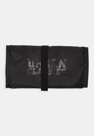 Fekete szövet táska, hengerdizájnnal, amelyet egy fekete pánt rögzít. Az elején a "URBAN CLASSICS" felirat található egy merész, halvány nyomattal.