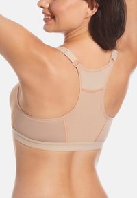 Sujeción deportiva beige con un diseño de espalda de nadador, con costuras en contraste naranja, tirantes ajustables y una tela suave y texturizada.
