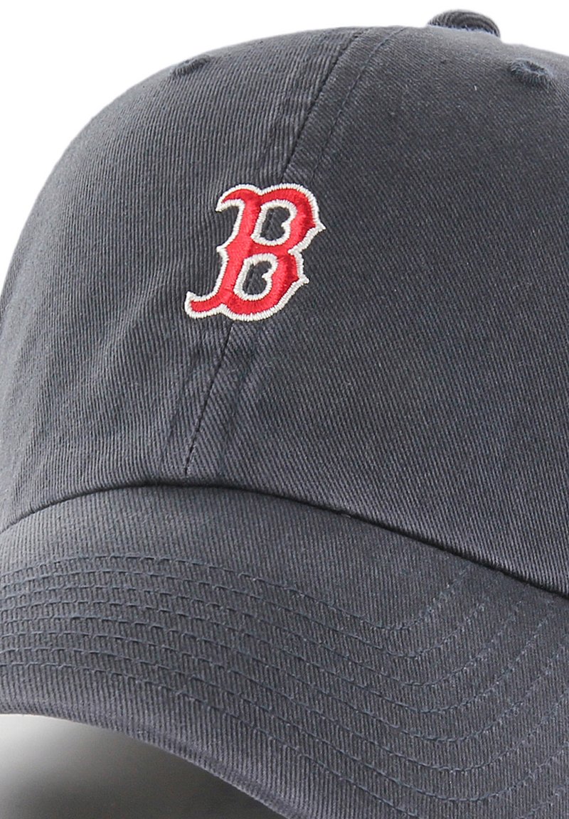 Casquette de baseball marine en coton avec une visière courbée, ornée d'un logo "B" rouge brodé à l'avant. Détails de surface texturés visibles.