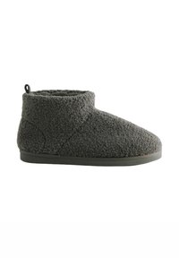 Tumma harmaa fleece nilkkasukkula, jossa on lenkkivetoketju takana ja tasainen, teksturoitu pohja.