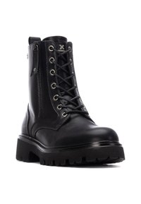 Bota de combate de cuero negro con cierre de cordones y cremallera, que cuenta con una suela robusta y acentos texturizados. Diseño resistente con costuras reforzadas.