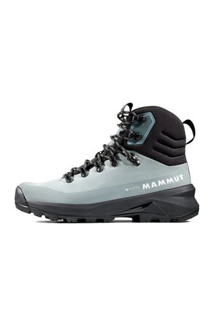Szare i czarne wysokie buty trekkingowe z sznurowadłami, wytrzymałą podeszwą, metką Gore-Tex i logo Mammut po boku.