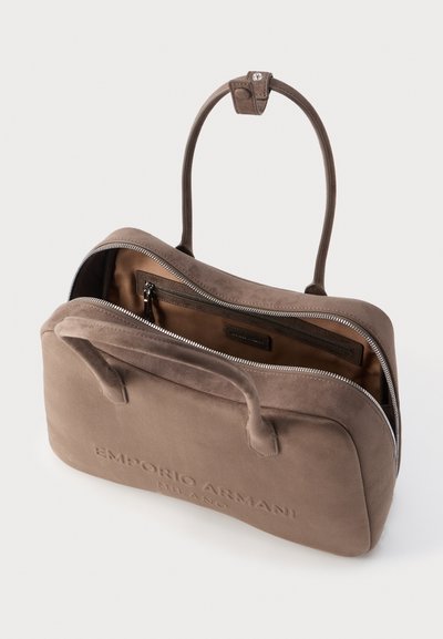 Τσάντα Emporio Armani Milano από τσόχα σε χρώμα φυστικί, με δύο χερούλια, μερικώς ανοιχτό φερμουάρ και ορατή εσωτερική τσέπη με φερμουάρ.