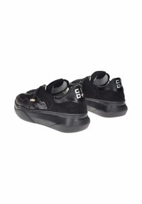 Sneaker nere con un mix di materiali scamosciati e lucidi, forma arrotondata, suola in gomma spessa e discreti accenti del logo sul retro.
