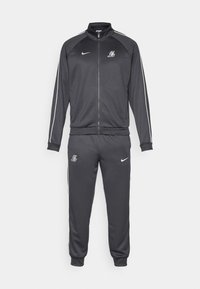 Mørkegrå Nike træningsdragt med lynlåsslukning på jakken og joggers, med hvid piping og Los Angeles Lakers logoer på bryst og lår.