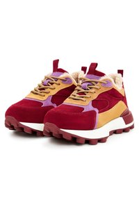Baskets épaisses avec des panneaux en daim rouge, moutarde et violet, des lacets beiges, des semelles épaisses à crampons et une doublure en mouton couleur crème.