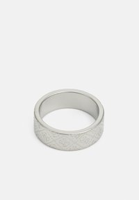 Bague en argent avec un design de bande plate, présentant des motifs embossés et un intérieur lisse. Fabriquée en métal avec une finition brossée.